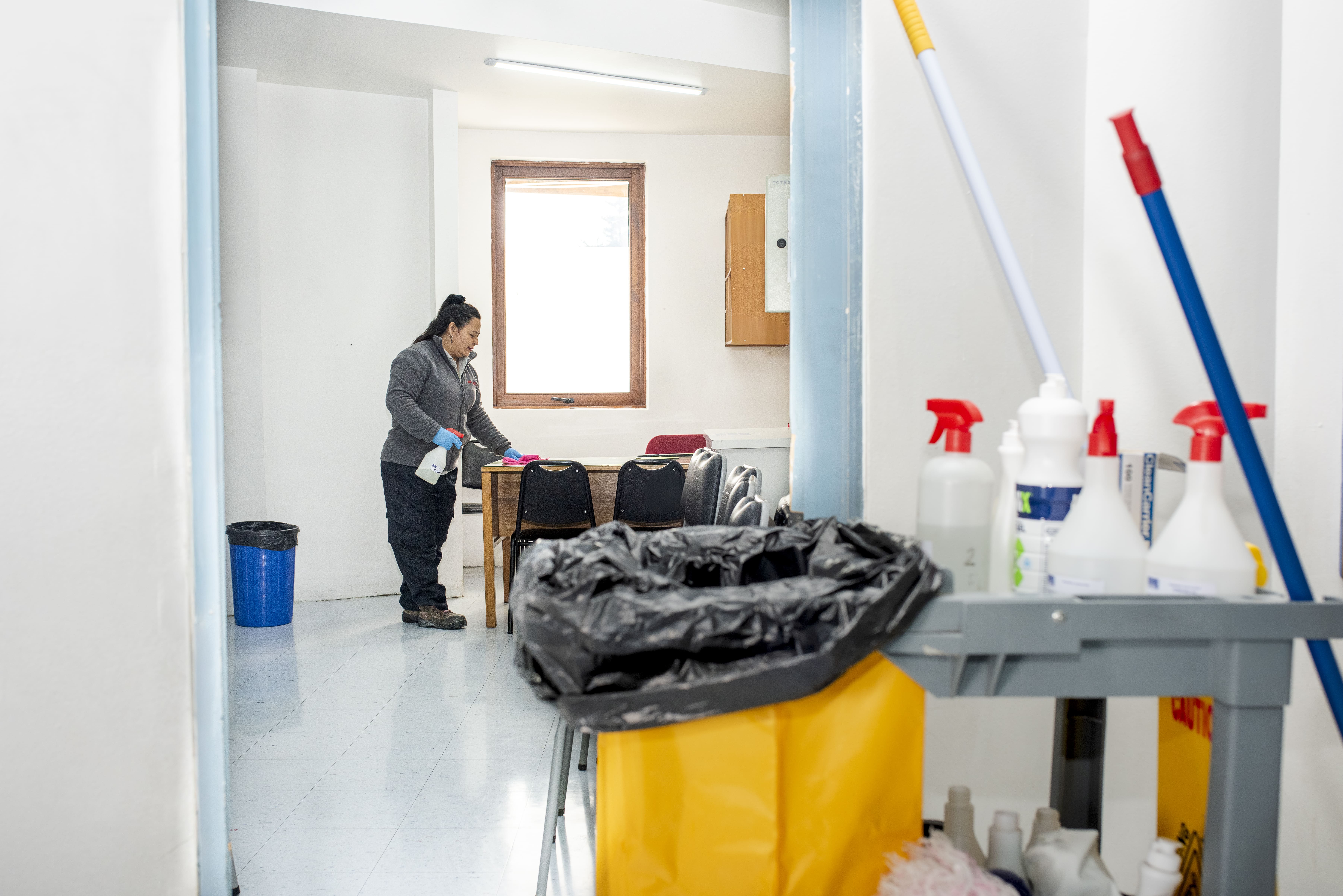 Profesional de Guzmán y Schmidt realizando limpieza de oficinas y salas de reuniones
